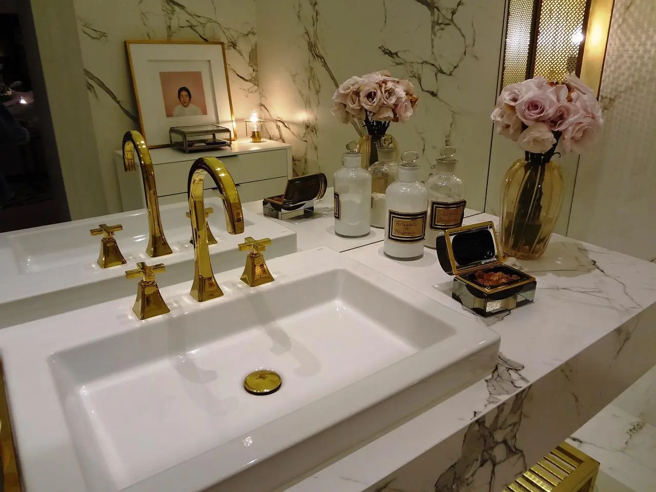 White marble vanity with a rectangular sink, gold taps and pink roses