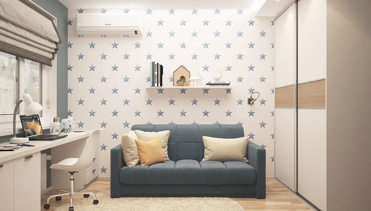 Teen room with star wallpaper, a grey sofa, a long white desk and a wardrobe