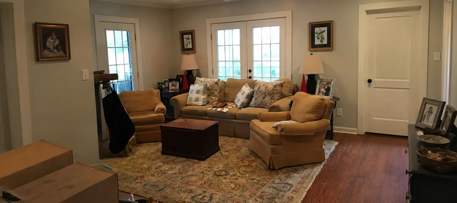 A lived-in living room with moving boxes and clutter, before AI Home Staging