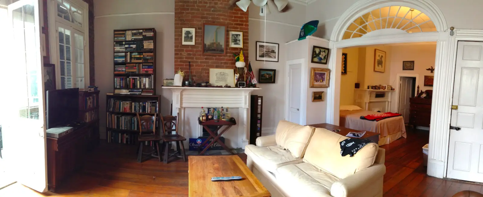 Parisian apartment style: an old apartment with a fanlight arch, a fireplace, bookshelves and a cream sofa