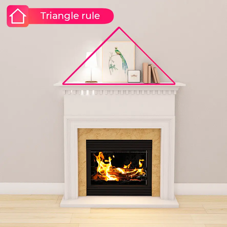 White fireplace mantel decorated with pieces arranged in a triangle around a framed bird print
